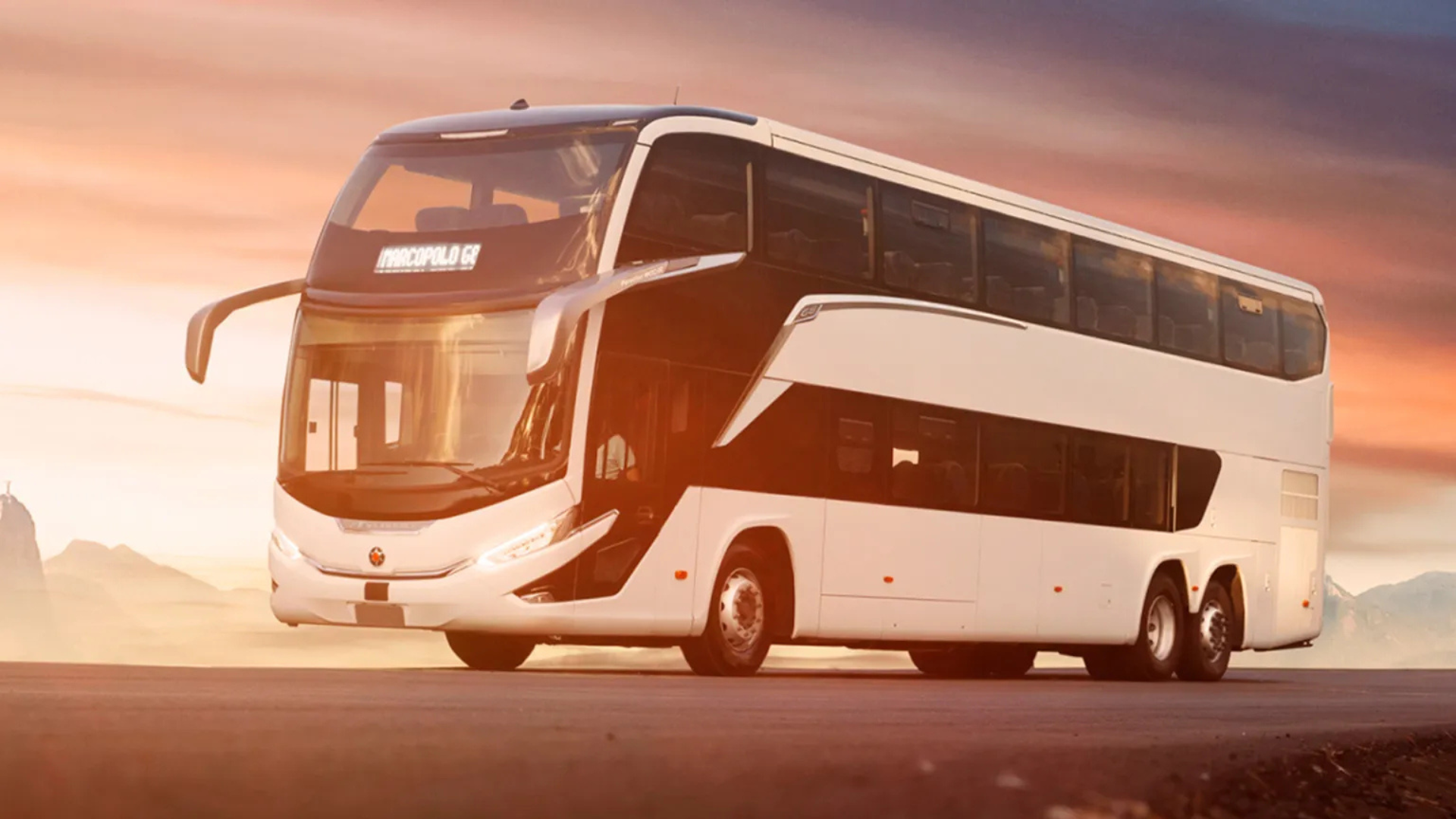 Ônibus rodoviário branco de dois andares em estrada ao entardecer