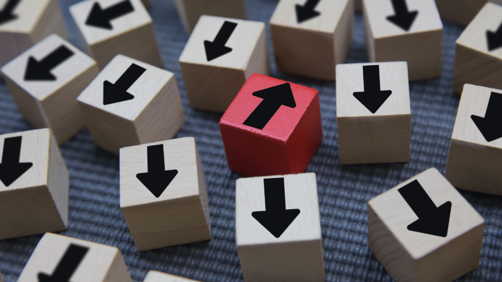 Cubo vermelho com seta preta para cima entre blocos bege com setas para baixo