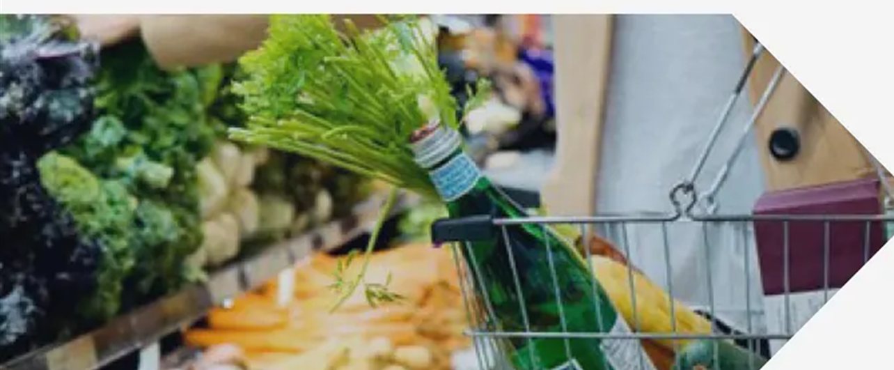 Foto de carrinho de compras com verduras em um corredor de supermercado