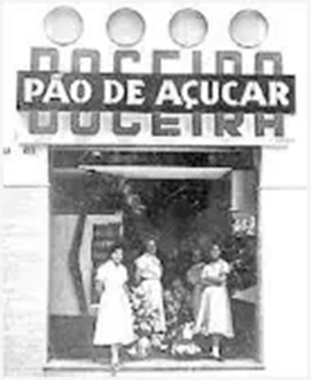 Foto antiga da fachada da Doceria Pão de Açúcar com três mulheres na entrada