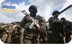 Soldados ucranianos armados junto a um tanque com bandeira da Ucrânia