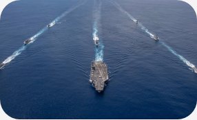 Navios de guerra navegando em formação no mar
