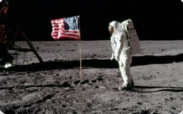 Astronauta ao lado da bandeira dos EUA na superfície da Lua